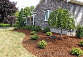 Fresh mulch installation next to a stone-front home by Elegant Landscaping